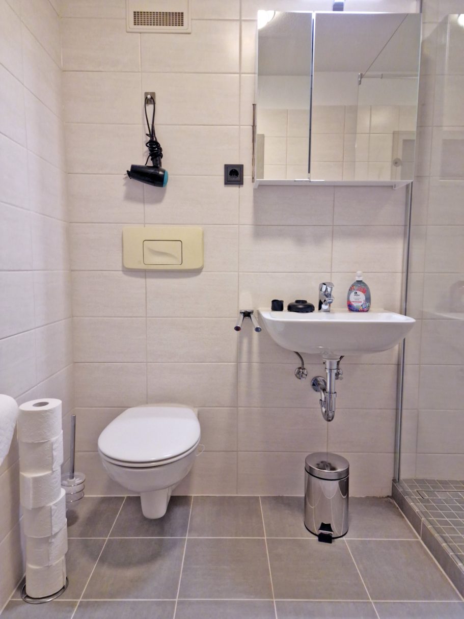 Bad Helles Badezimmer mit Toilette, Waschbecken und Duschbereich.