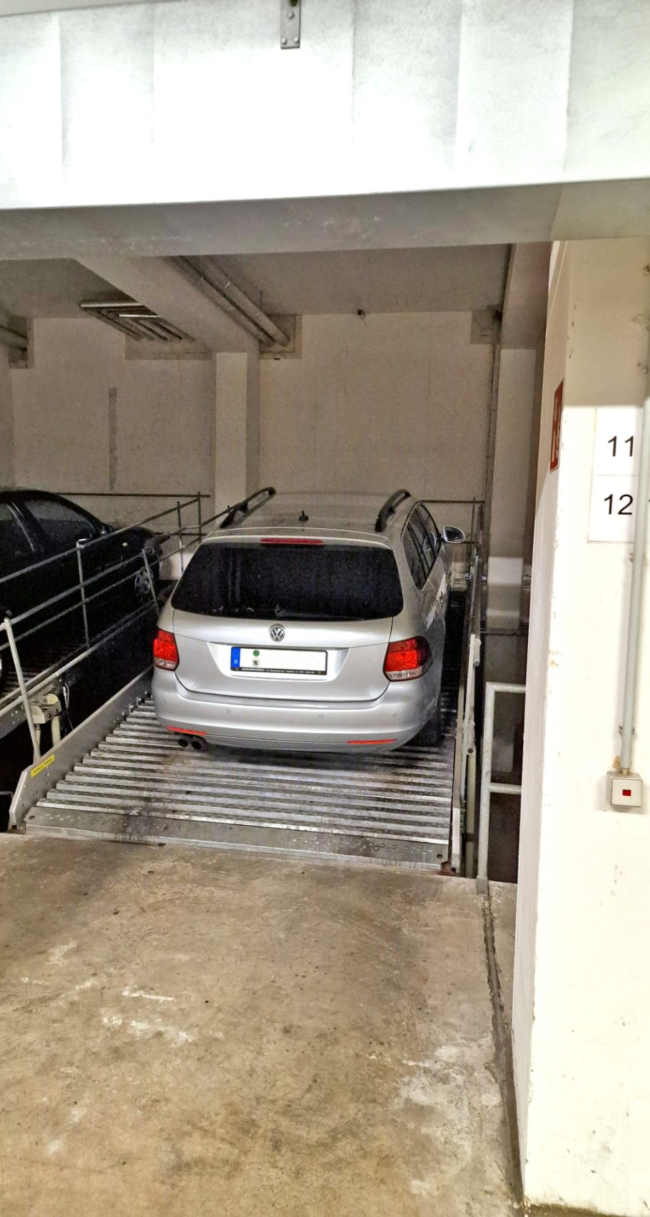 Stellplatz Ein silbernes Auto steht in einer überdachten Parkgarage.