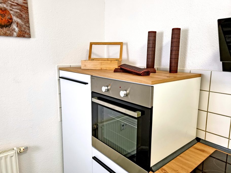 Küche Moderne Küche mit Holzoberfläche, Ofen und dekorativen Gegenständen.